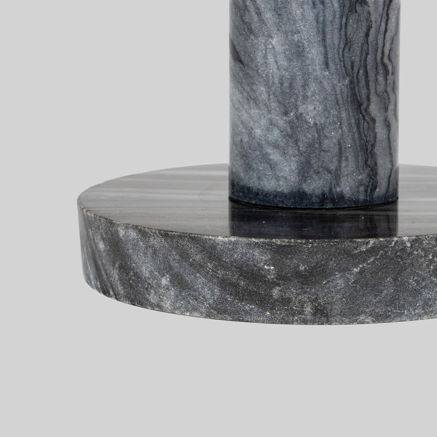 Small round cocktail table with marble top and brass base on a light gray background.