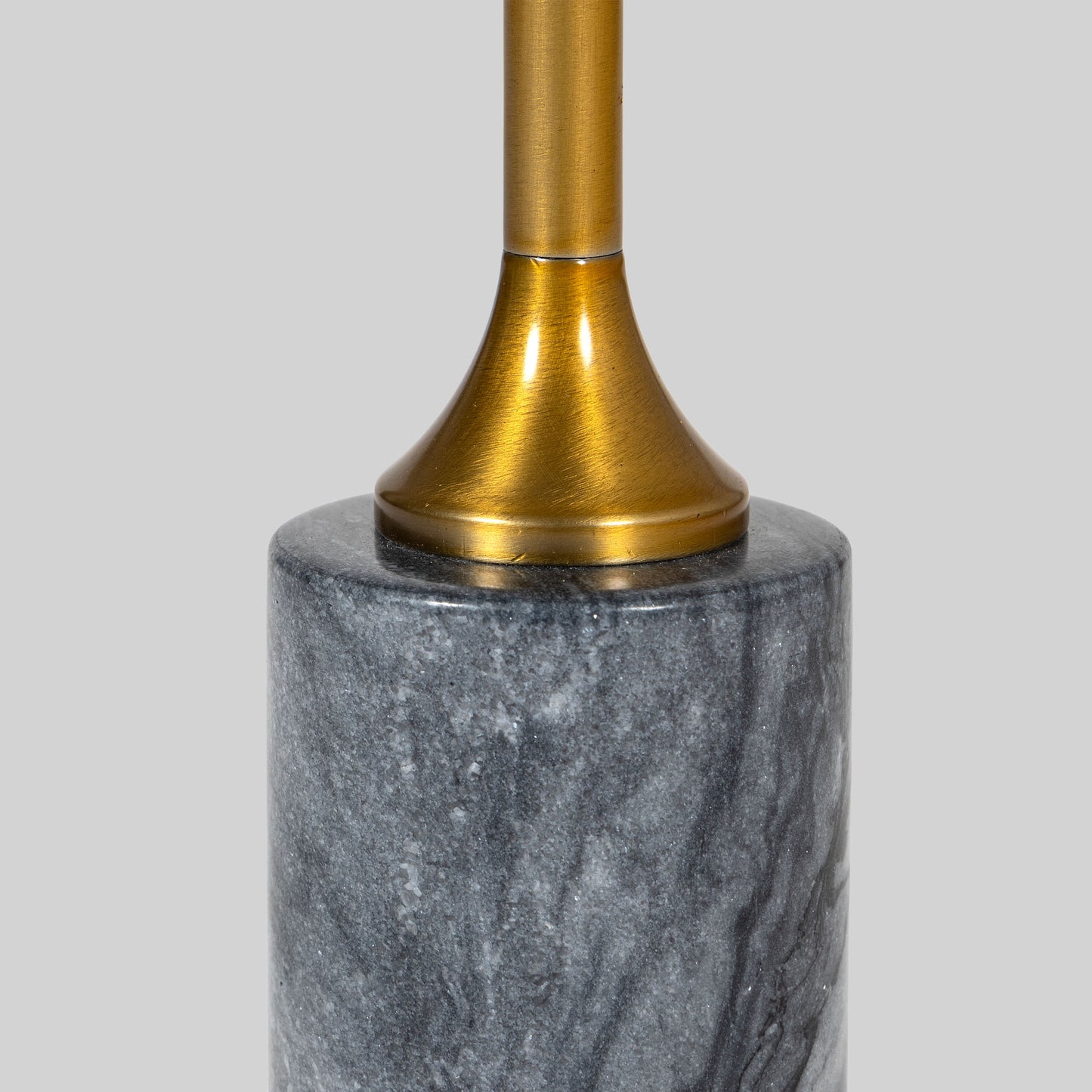 Small round cocktail table with marble top and brass base on a light gray background.