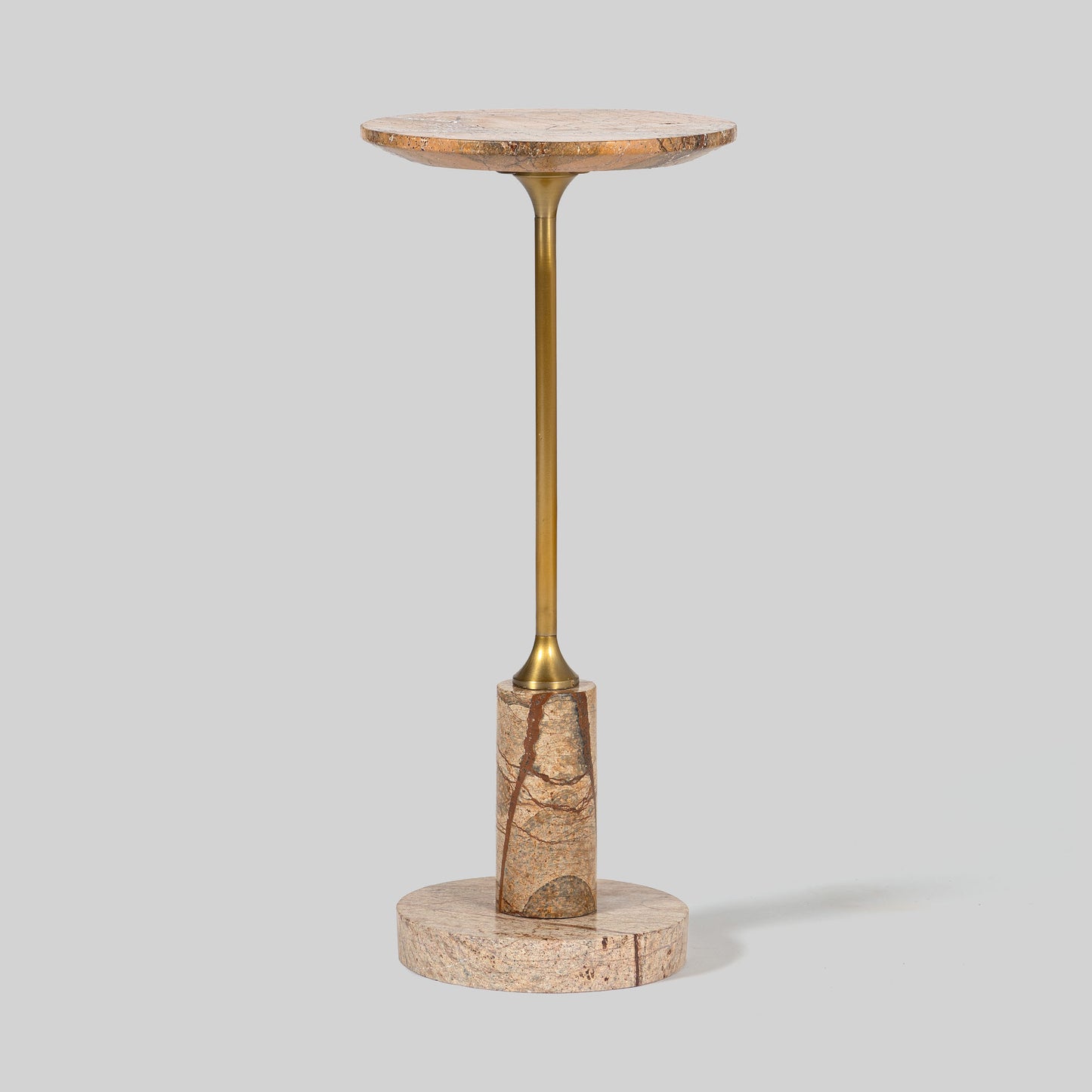 Small round cocktail table with marble top and brass base on a light gray background.