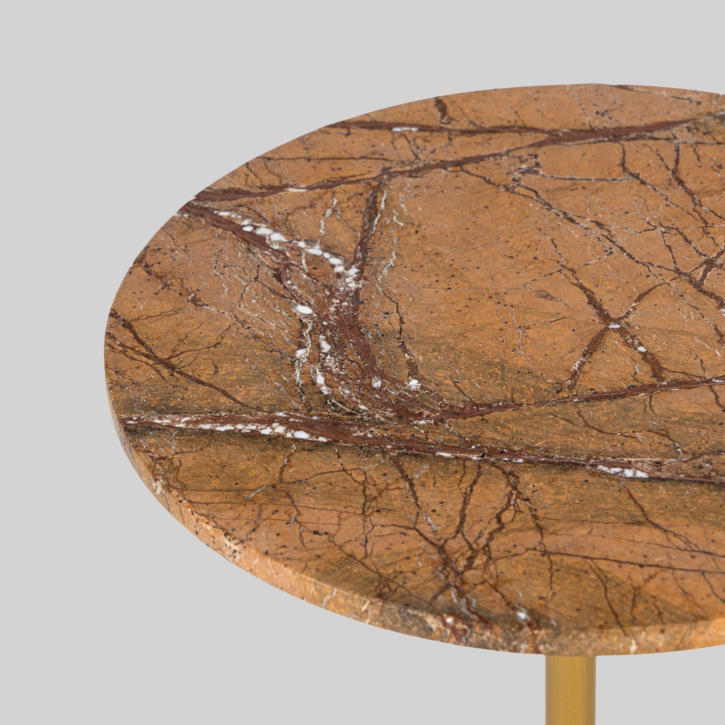 Small round cocktail table with marble top and brass base on a light gray background.