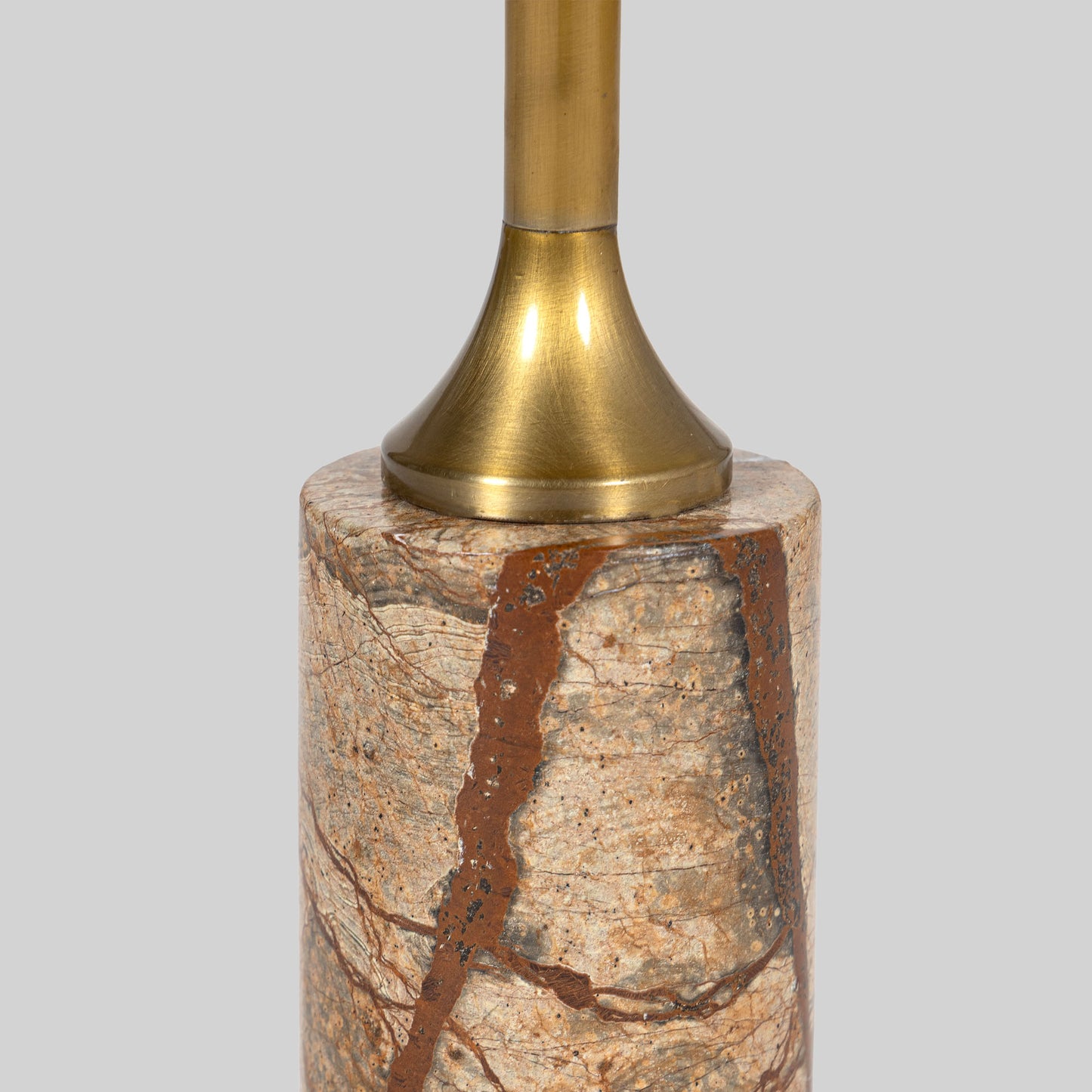 Small round cocktail table with marble top and brass base on a light gray background.