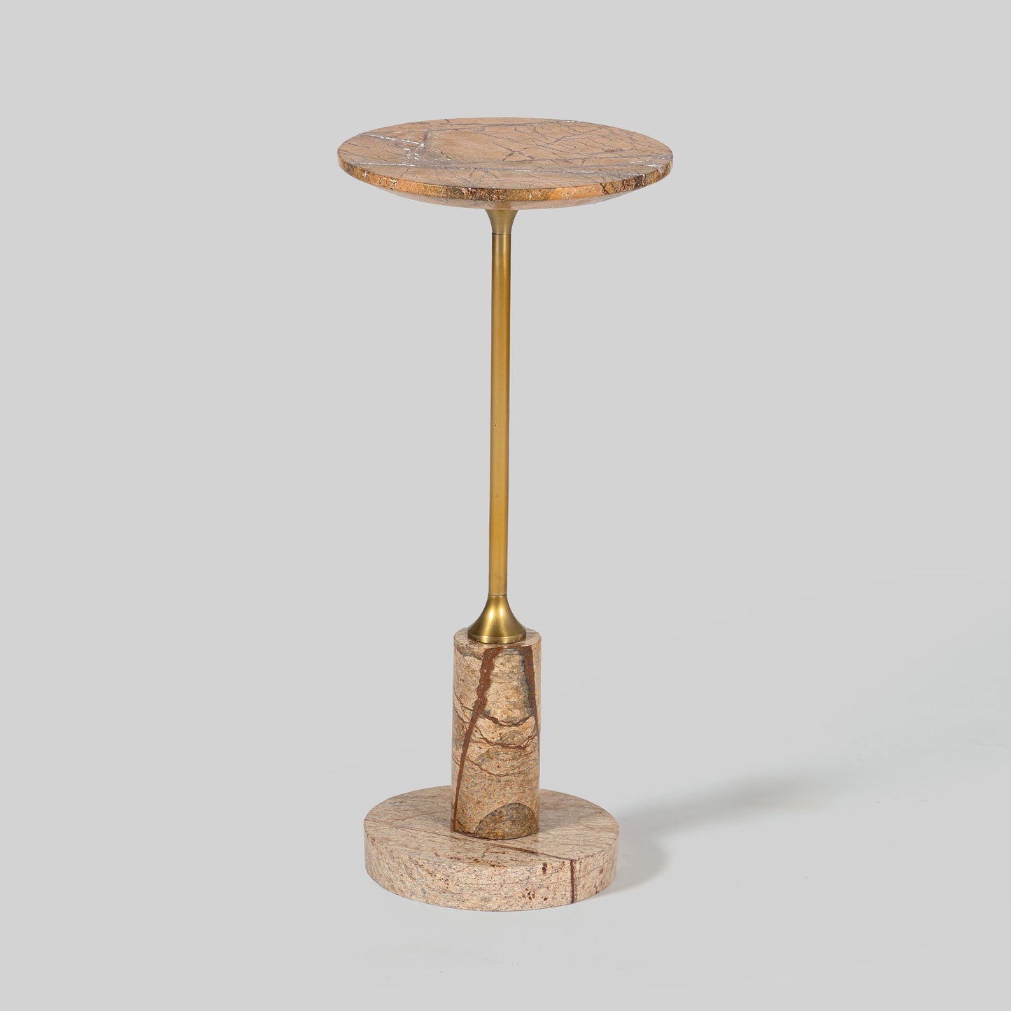 Small round cocktail table with marble top and brass base on a light gray background.