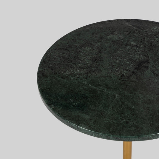 Small round cocktail table with marble top and brass base on a light gray background.