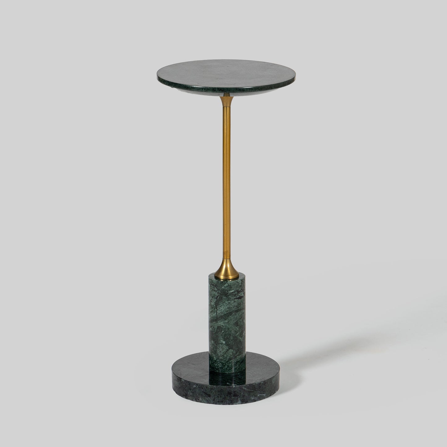Small round cocktail table with marble top and brass base on a light gray background.