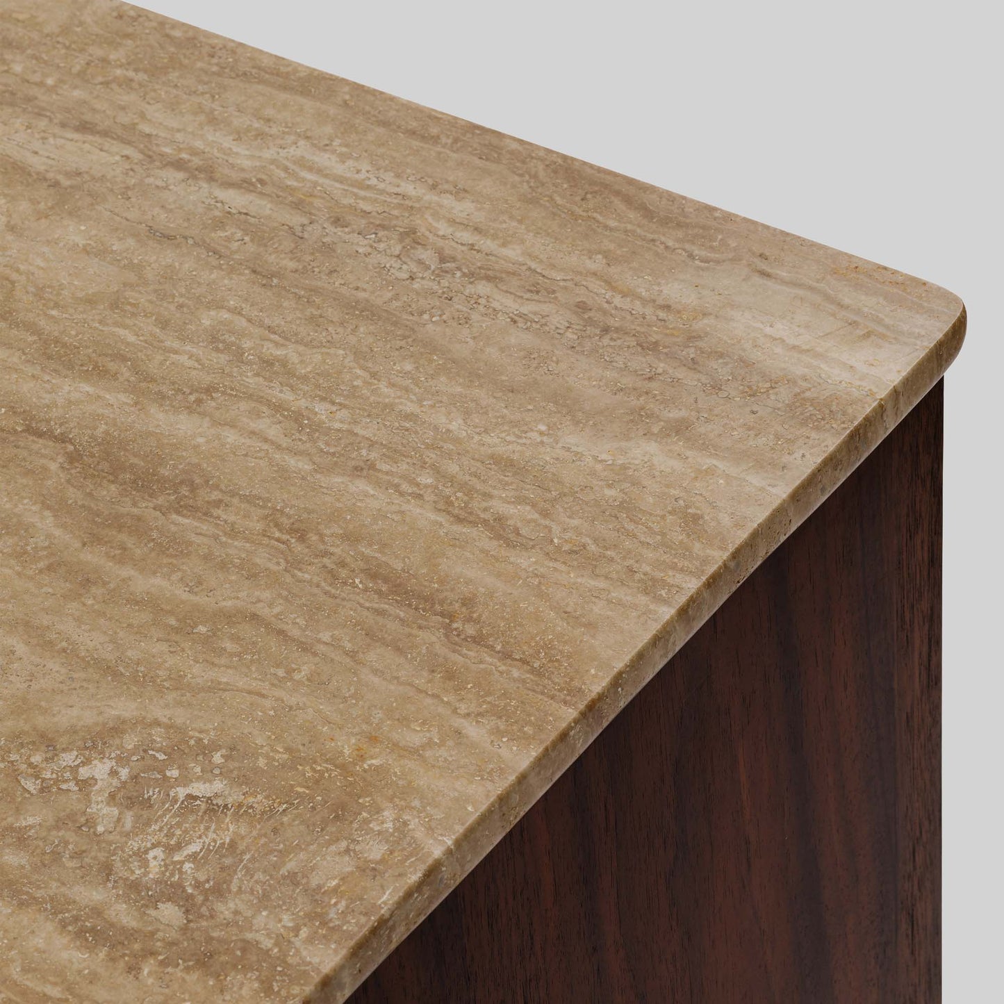 Wood sideboard with travertine stone top on light gray background.
