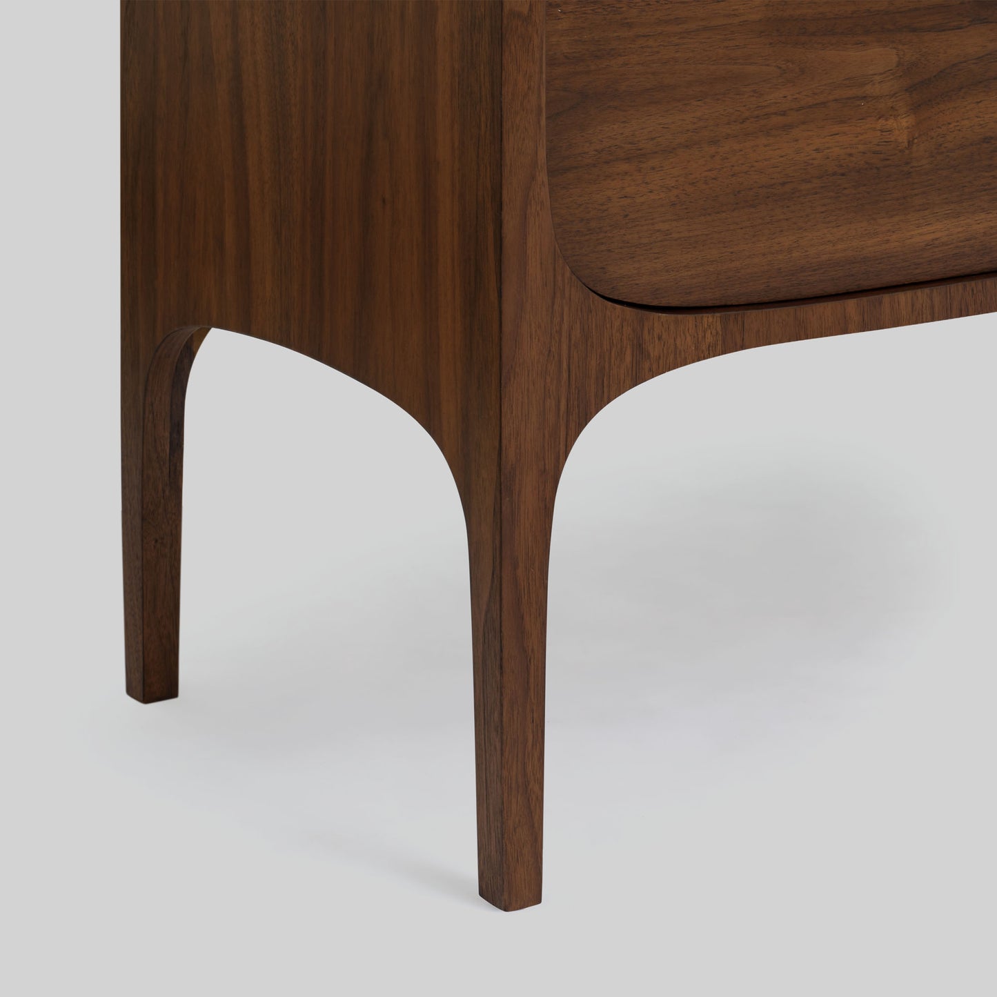 Wood sideboard with travertine stone top on light gray background.