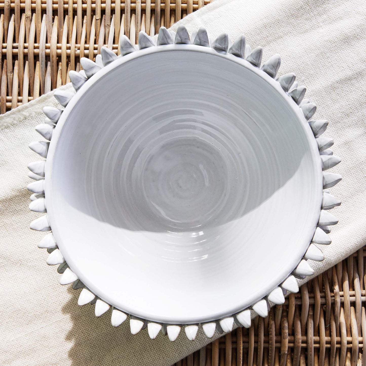 Petal decorative terracotta bowl top-down view on rattan table.