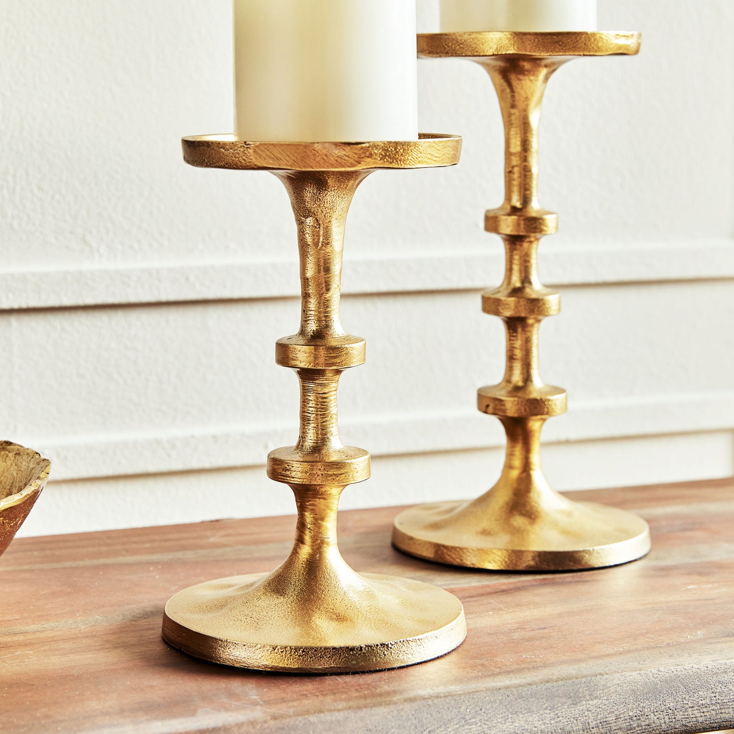 Petite minimalist pillar candleholders, set of 2, in gold finish, closeup view of base.