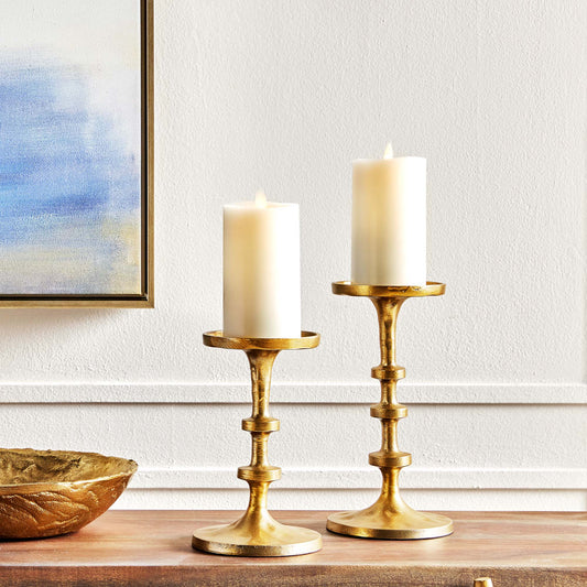 Petite minimalist pillar candleholders, set of 2, in gold finish, stylized on console table.