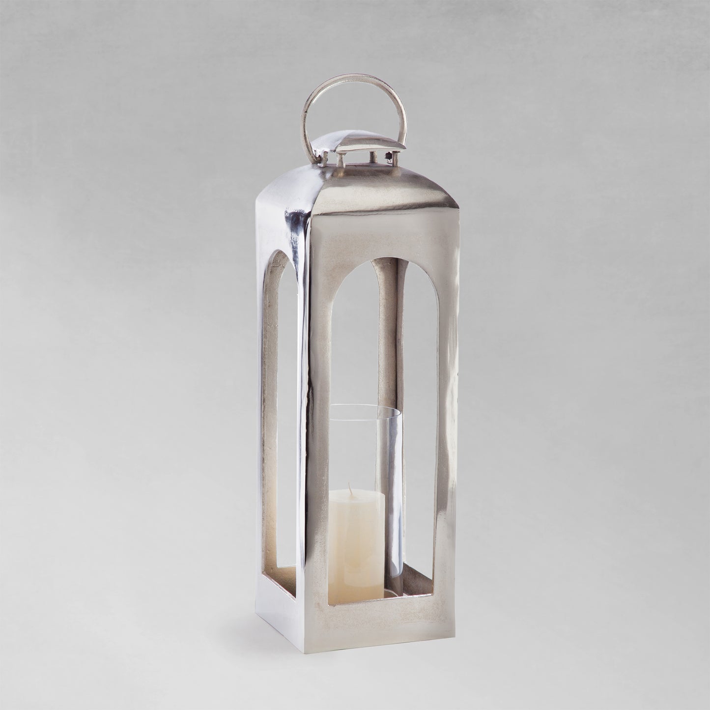 Large polished metal lantern with gray background.
