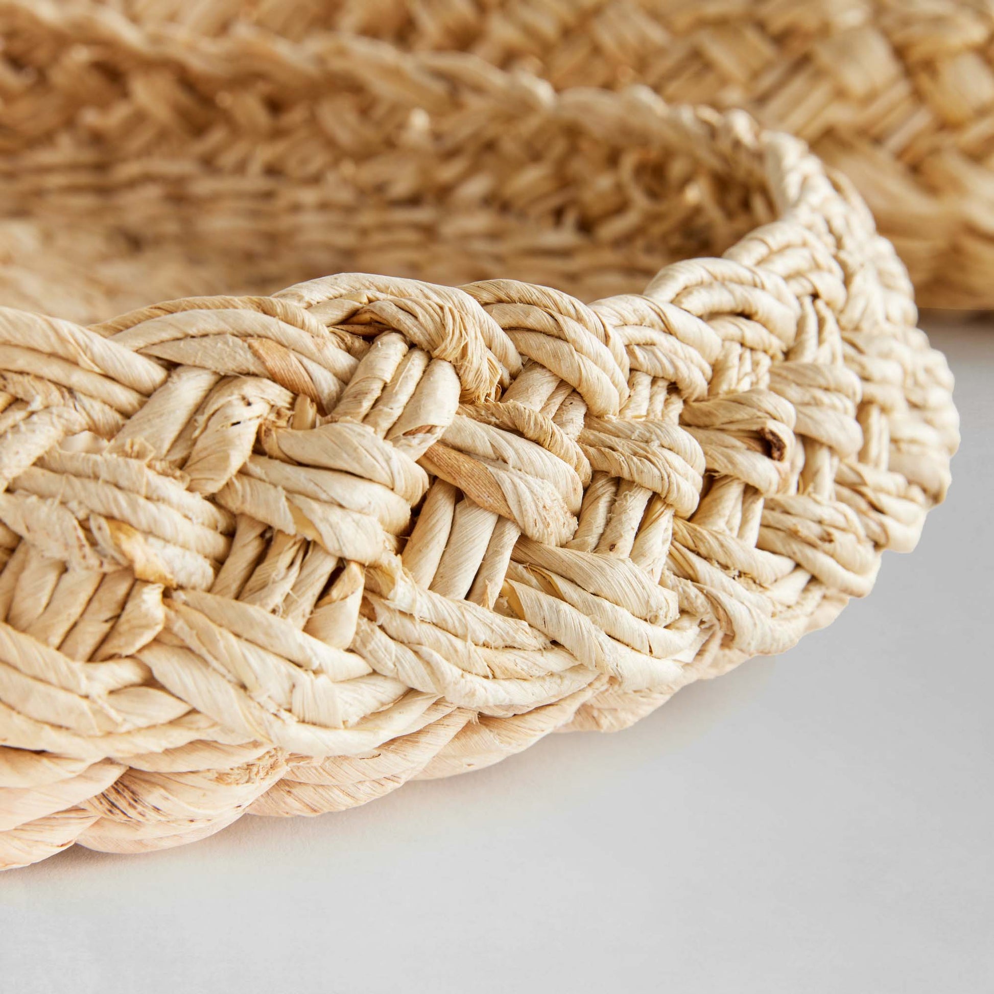 Round braided trays closeup with gray background.
