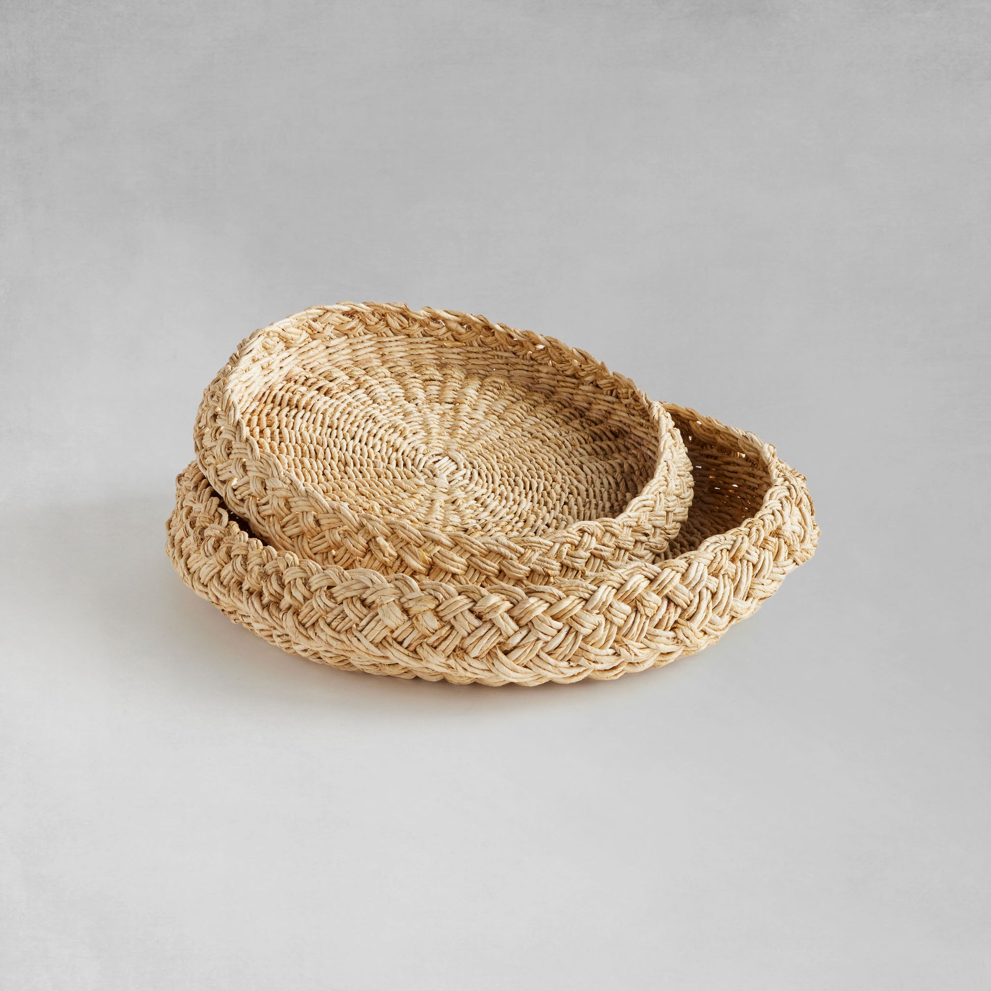 Round braided trays nested with gray background.