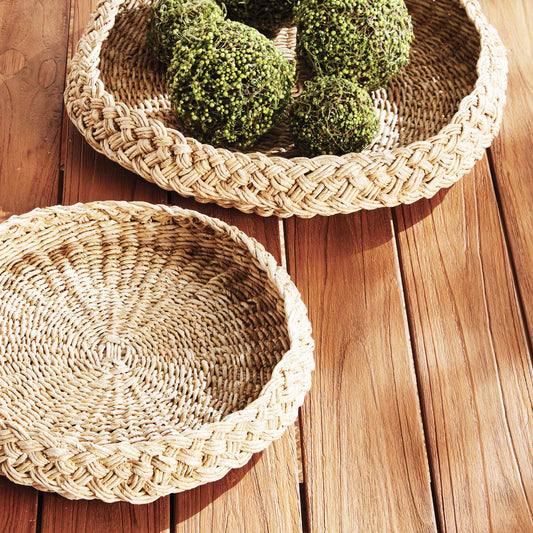 Round braided trays styled on outdoor dining table.