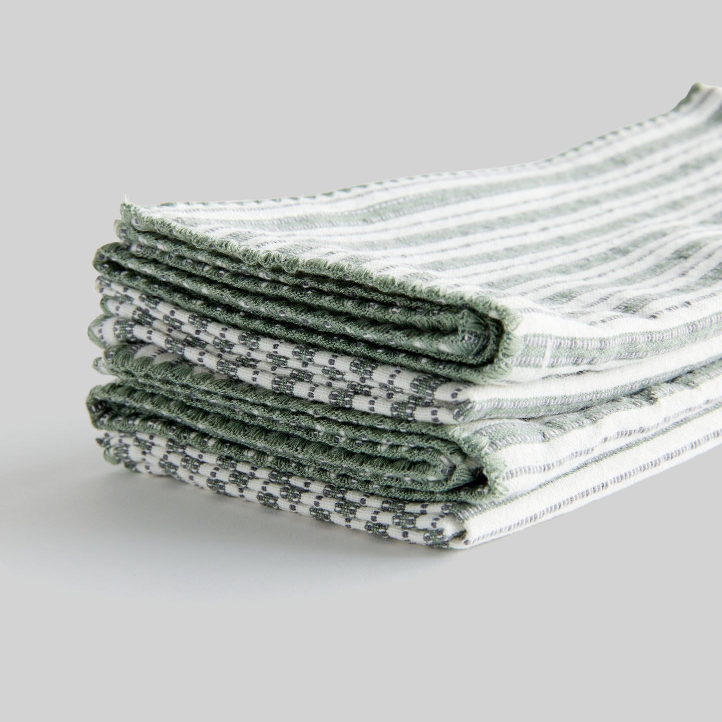 Sage green striped square cotton dinner napkins set of 4, closeup view of edge detailing.