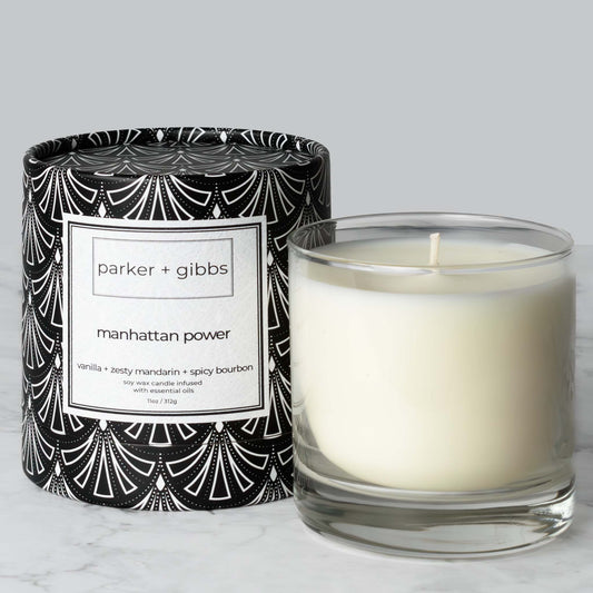 Luxury scented soy wax blend candle with vanilla and bourbon essential oils on marble table with gray background.