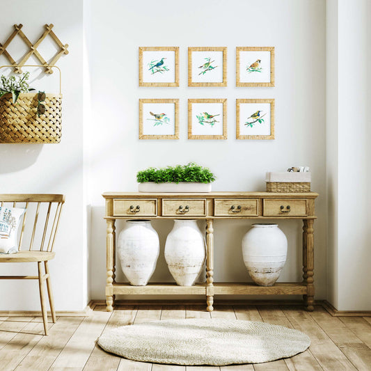Songbirds gallery wall art set stylized over wooden console table with ceramic jars.
