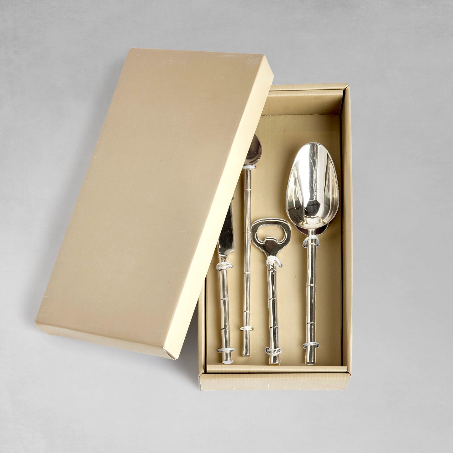 Stainless steel bamboo style barware tools set in box with gray background.