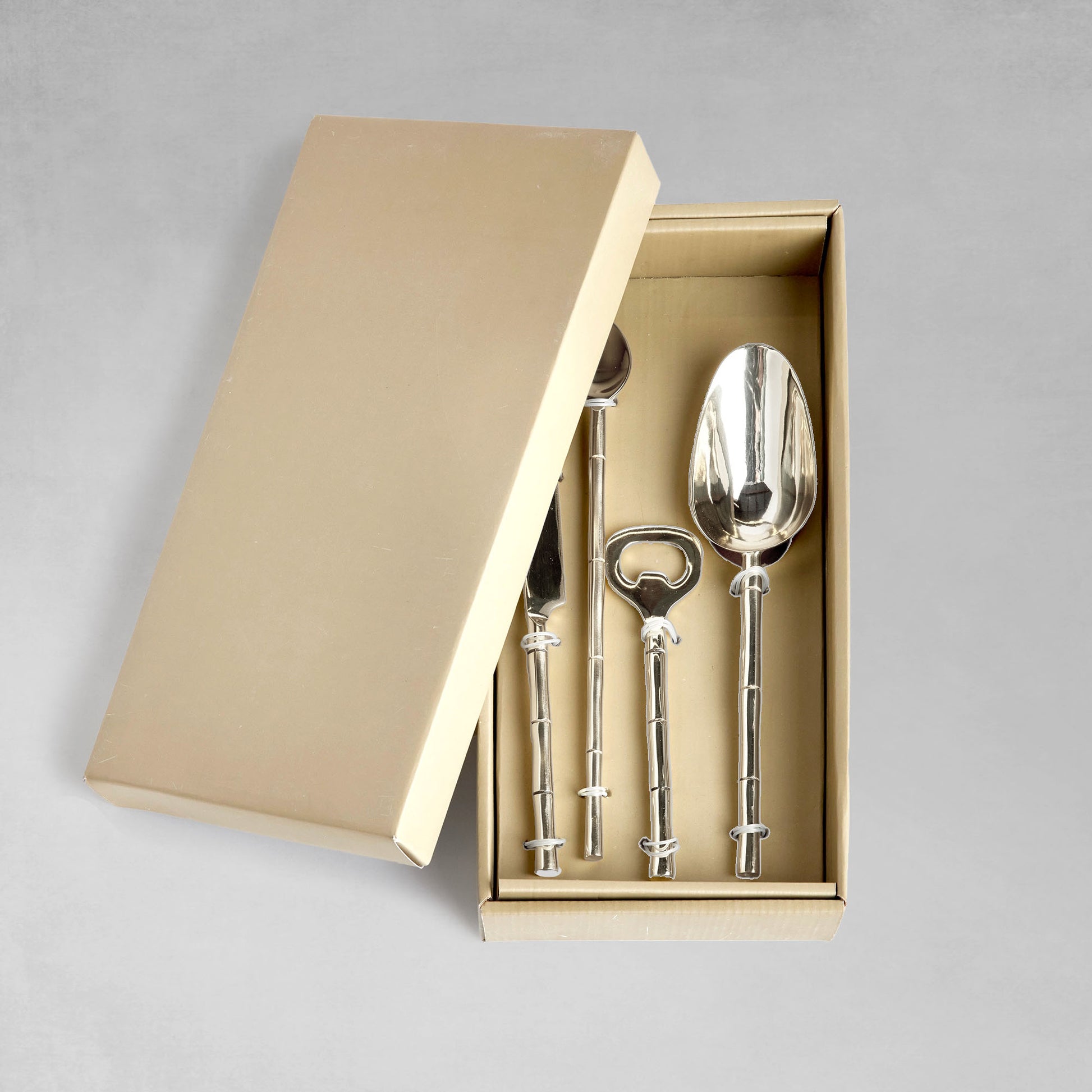 Stainless steel bamboo style barware tools set in box with gray background.