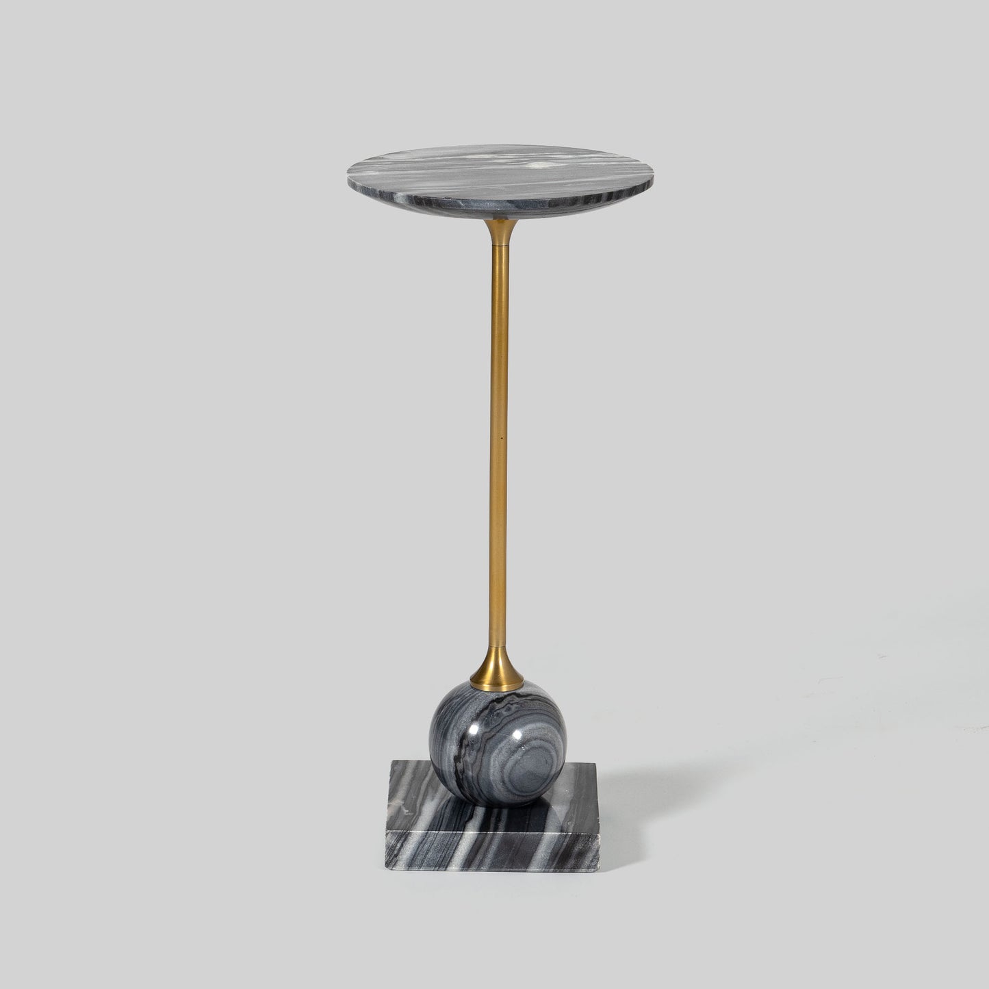 Small round cocktail table with marble top and brass base on a light gray background.