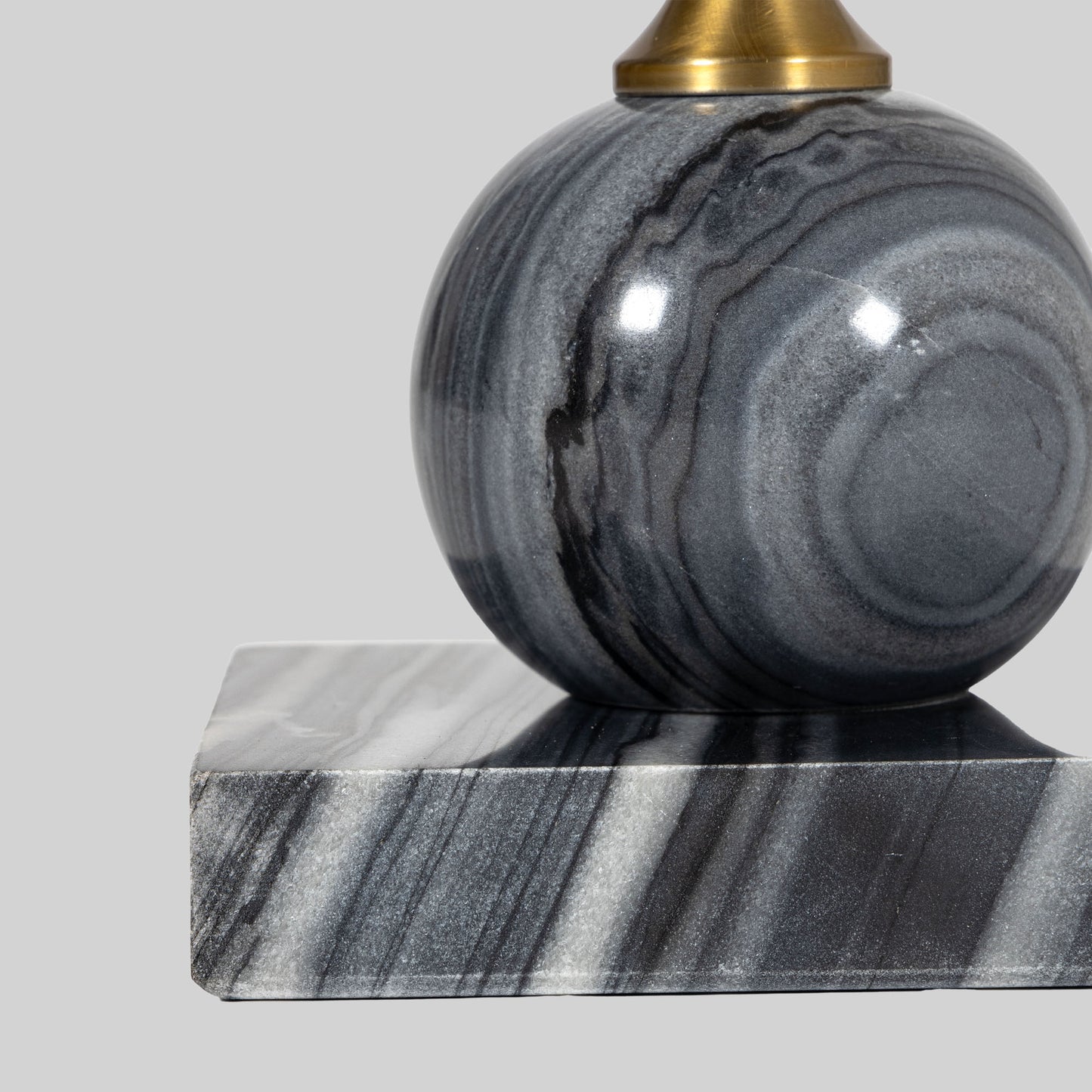 Small round cocktail table with marble top and brass base on a light gray background.
