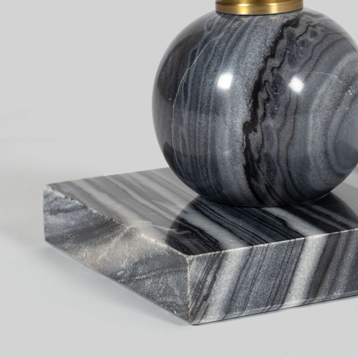 Small round cocktail table with marble top and brass base on a light gray background.