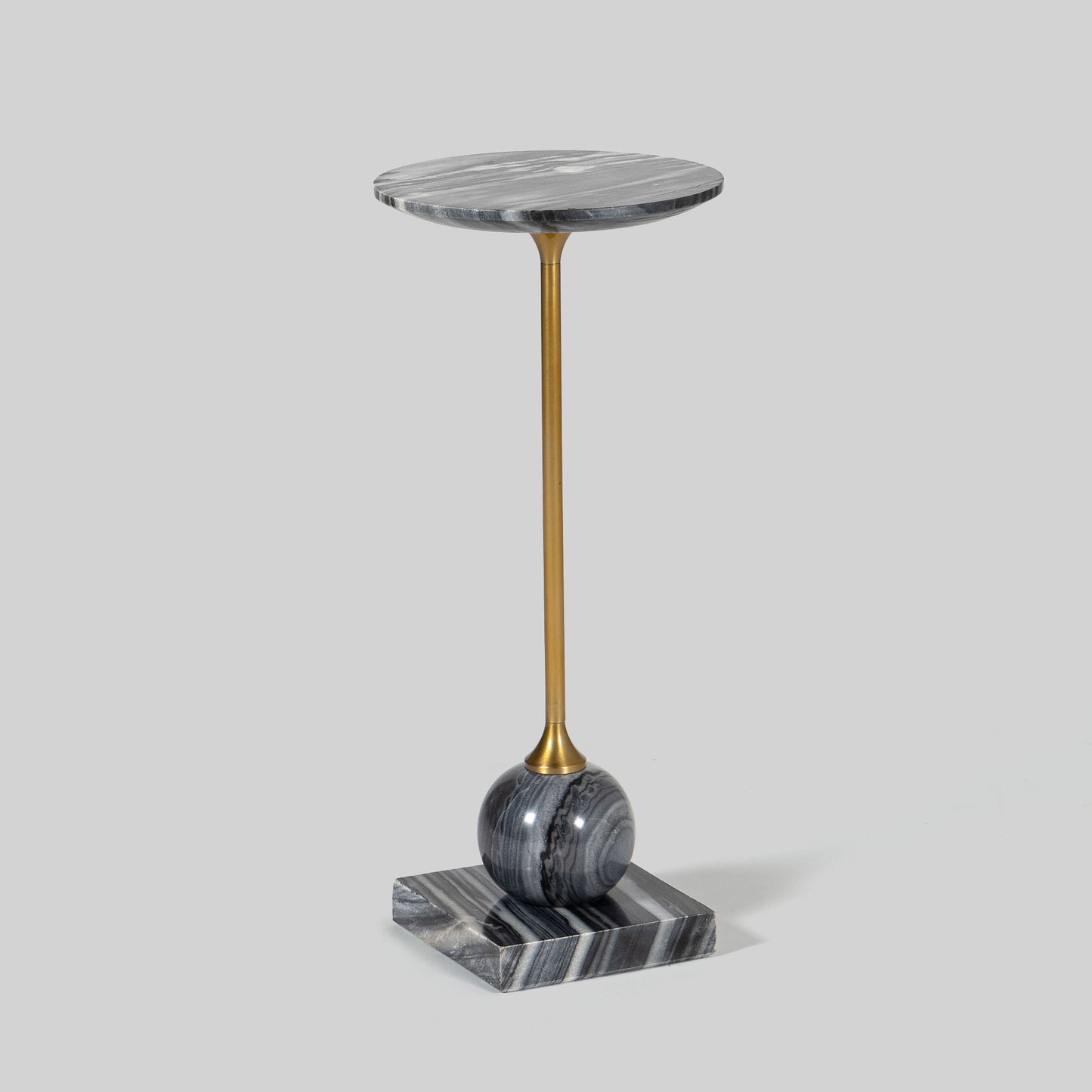 Small round cocktail table with marble top and brass base on a light gray background.