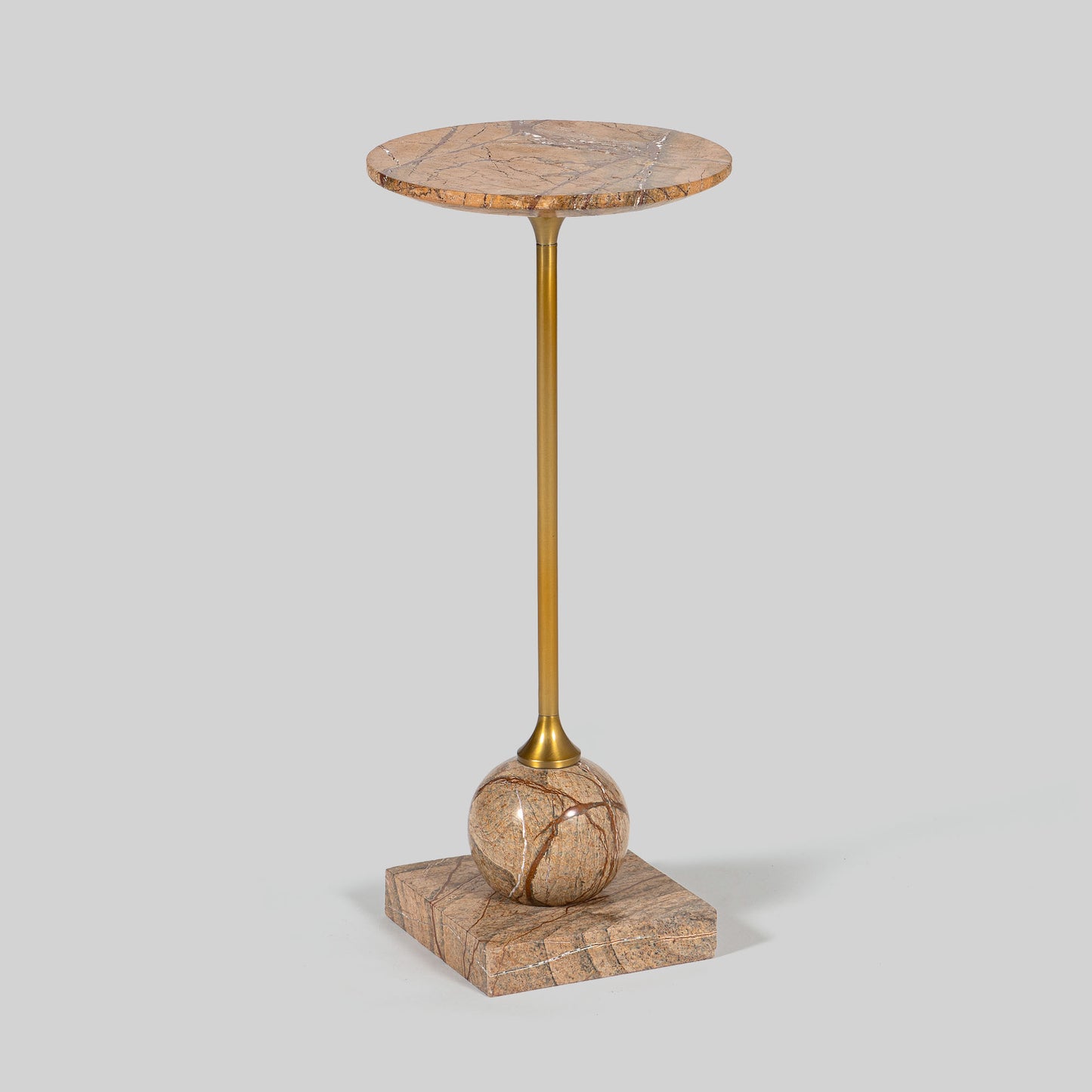 Small round cocktail table with marble top and brass base on a light gray background.