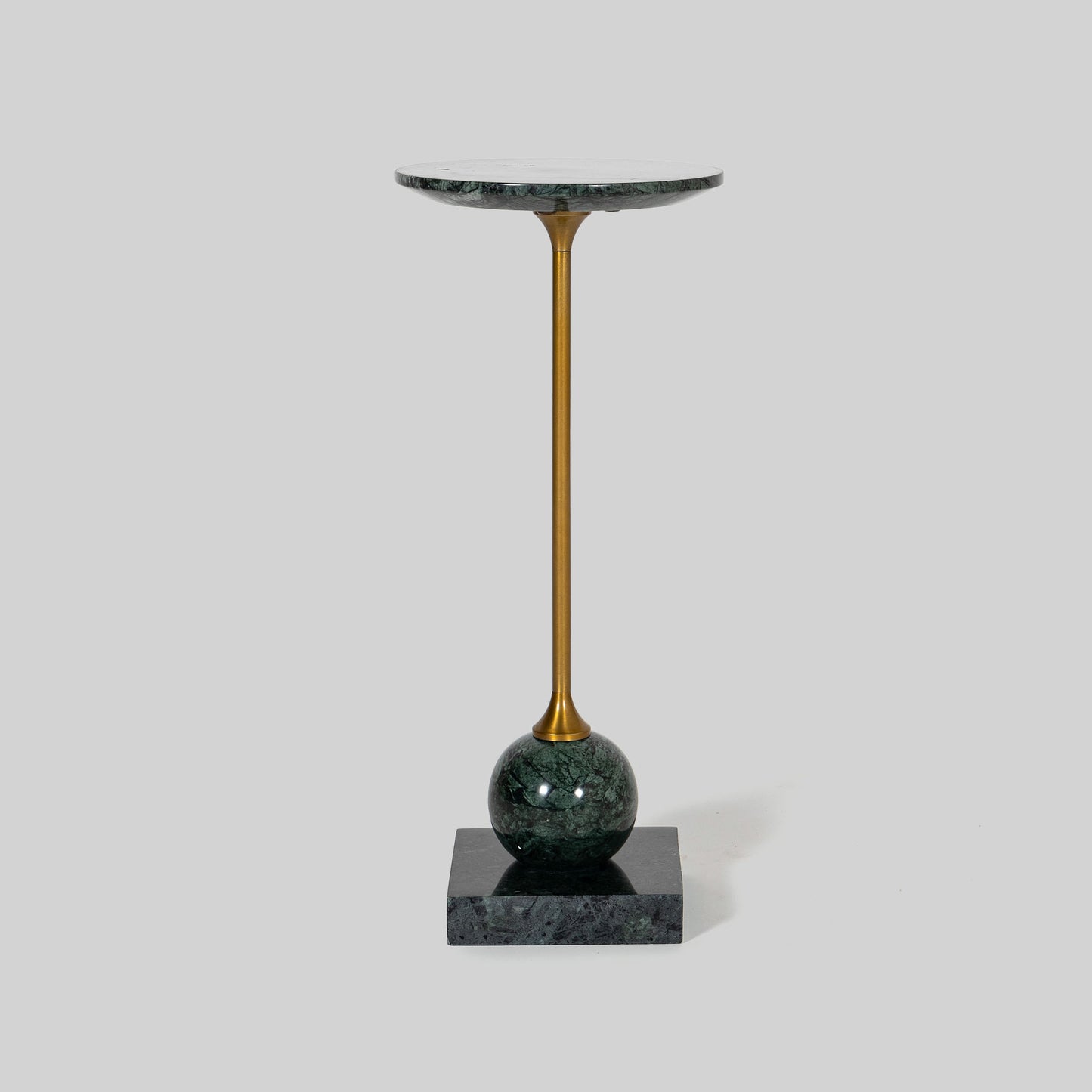 Small round cocktail table with marble top and brass base on a light gray background.
