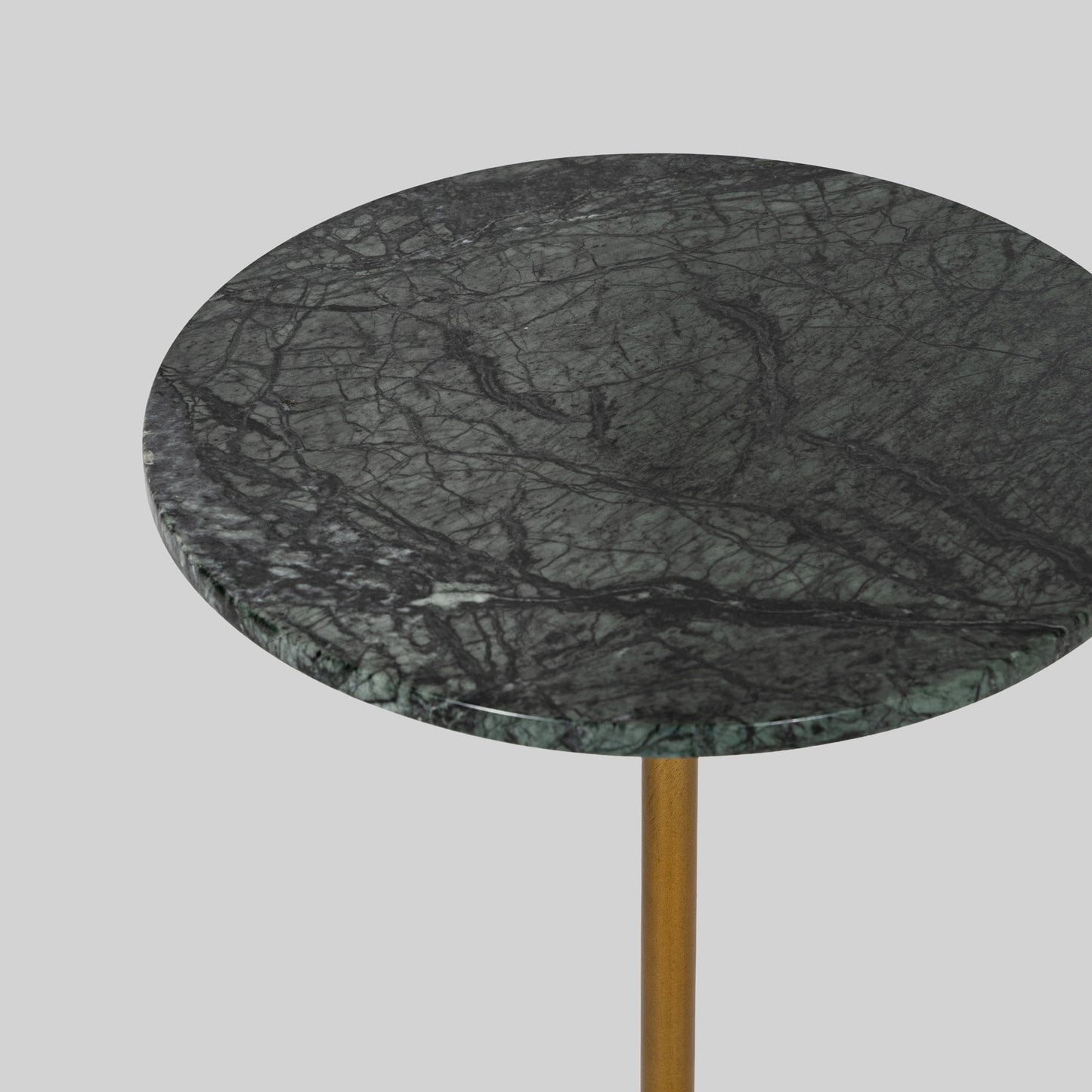 Small round cocktail table with marble top and brass base on a light gray background.