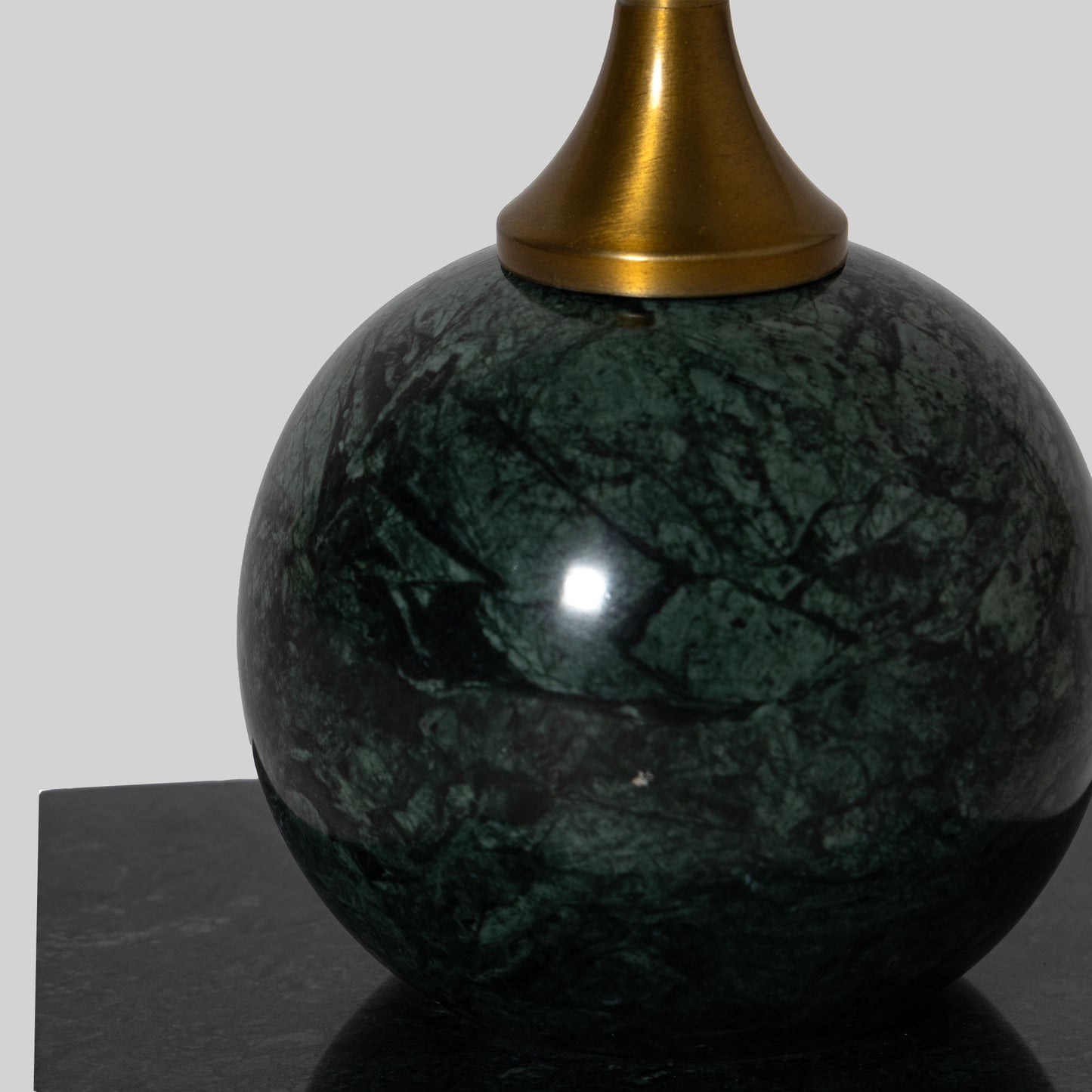 Small round cocktail table with marble top and brass base on a light gray background.