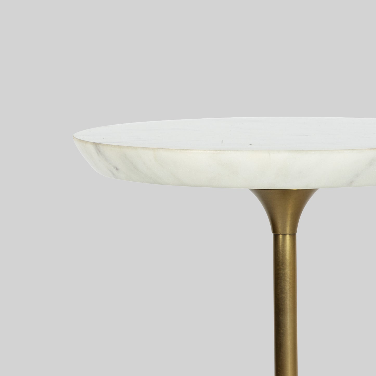 Small round cocktail table with marble top and base on a gray background.
