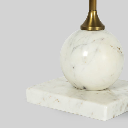 Closeup of small round cocktail table with marble top and base on a gray background.