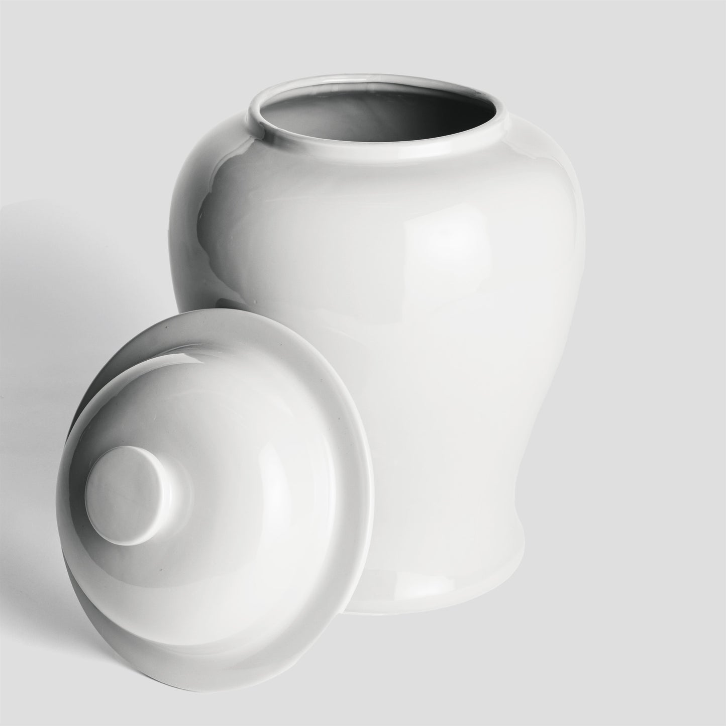 White ceramic lidded ginger jar, large, with lid removed with gray background.