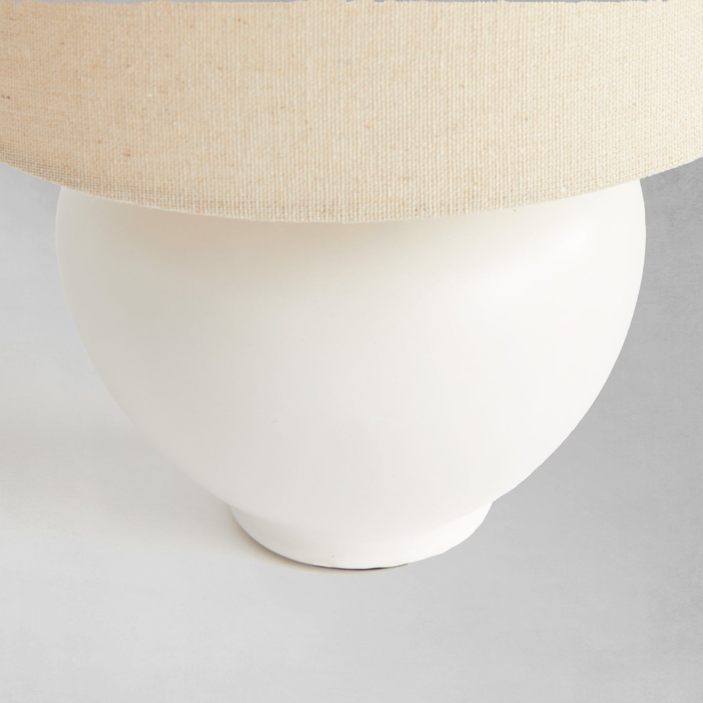 White ceramic mini lamp, closeup view of lamp base.