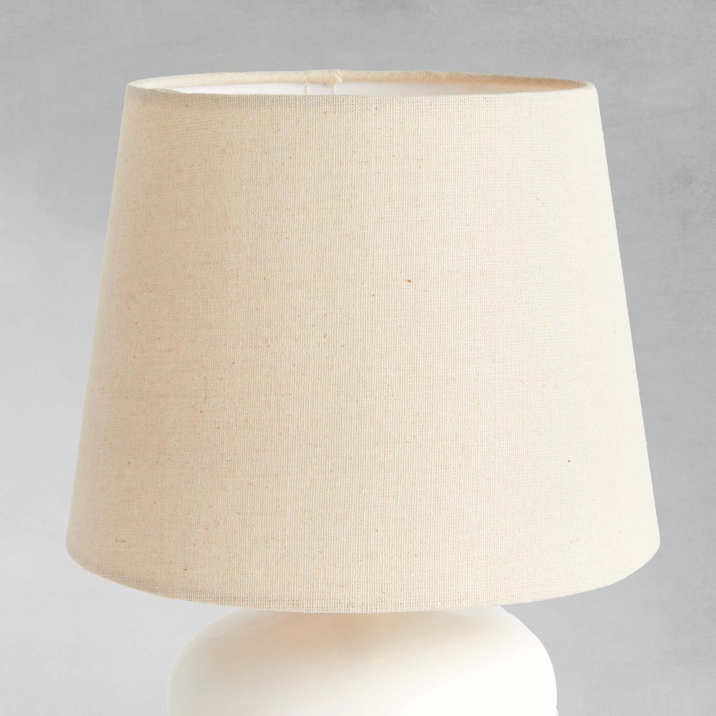 White ceramic mini lamp, closeup view of lampshade.