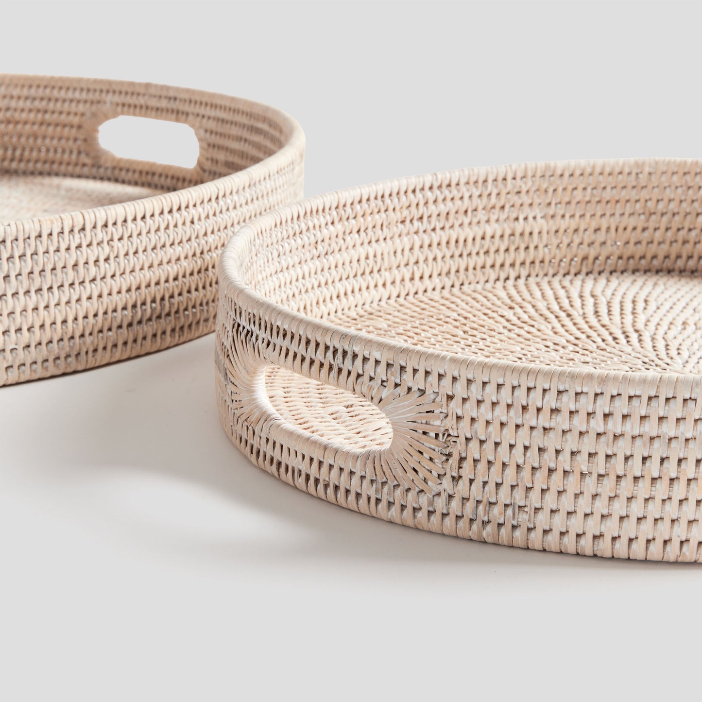 Woven ottoman trays set with light finish, handle closeup, with gray background.