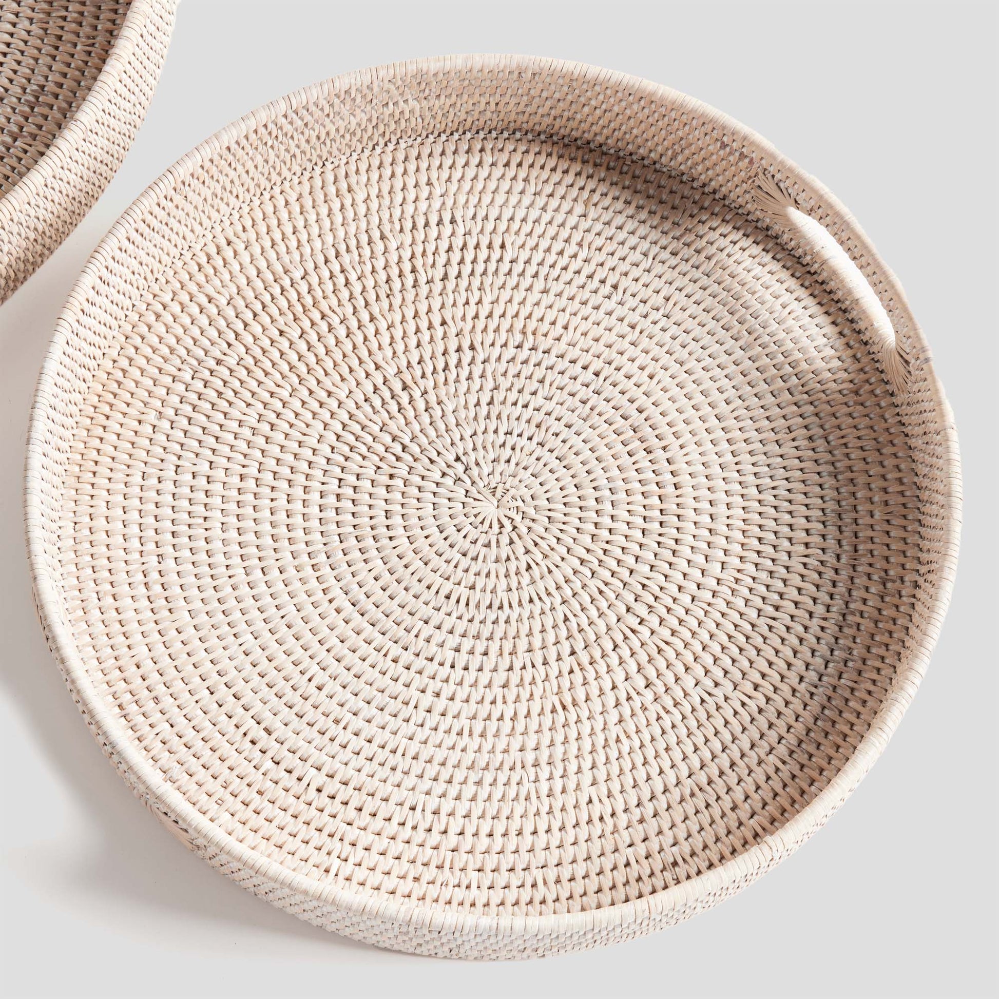Woven ottoman tray in small size with light finish and gray background.