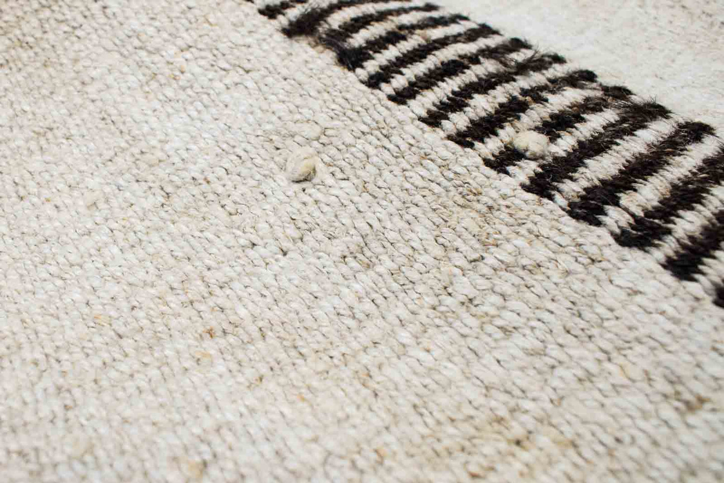 Closeup of handwoven Turkish kilim sisal pillow cover in sand with brown ticked bar stripe.