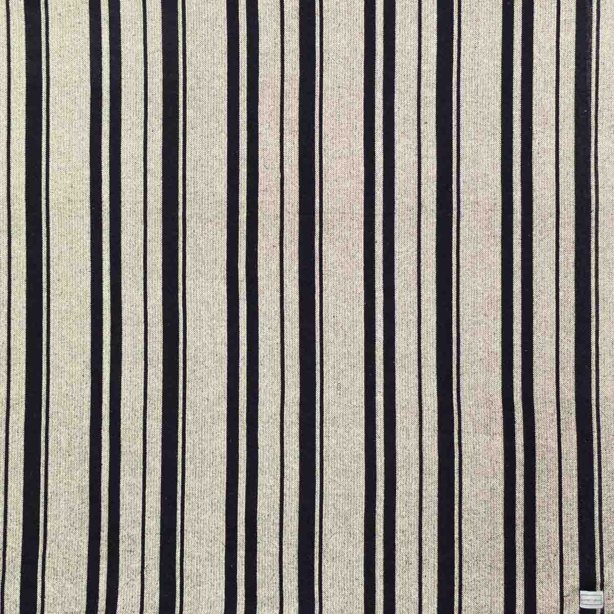 Cotton throw blanket with sand and black stripes.
