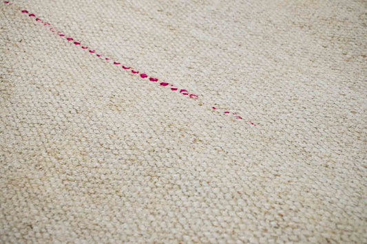 Handwoven Turkish kilim hemp pillow cover fabric in sand and cream with single pink stitch.