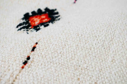 Handwoven Turkish kilim sisal pillow cover fabric in cream with orange and blue design accents.