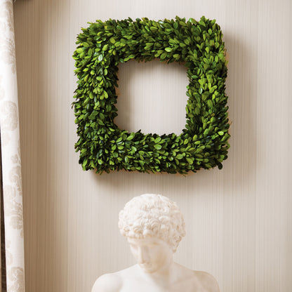 16" square preserved boxwood wreath with open window and sculpture.