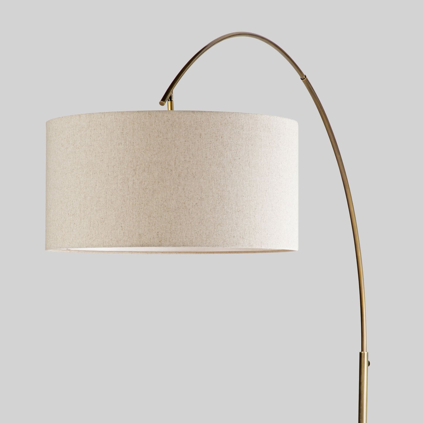 Floor lamp with a curved arm and wooden base on a light gray background.