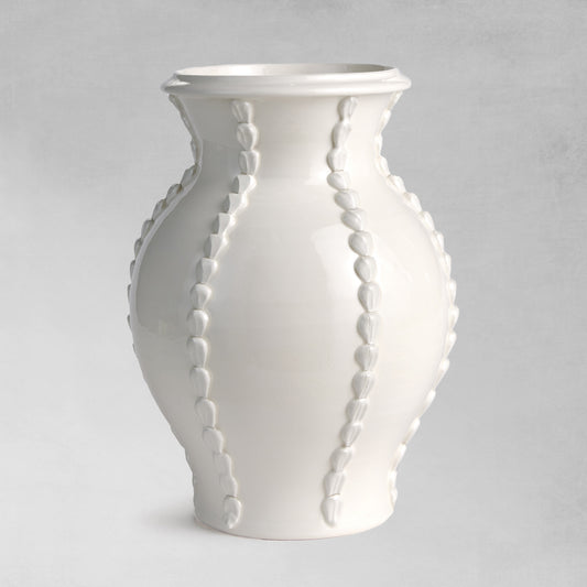 Beaded white ceramic vase with gray background.