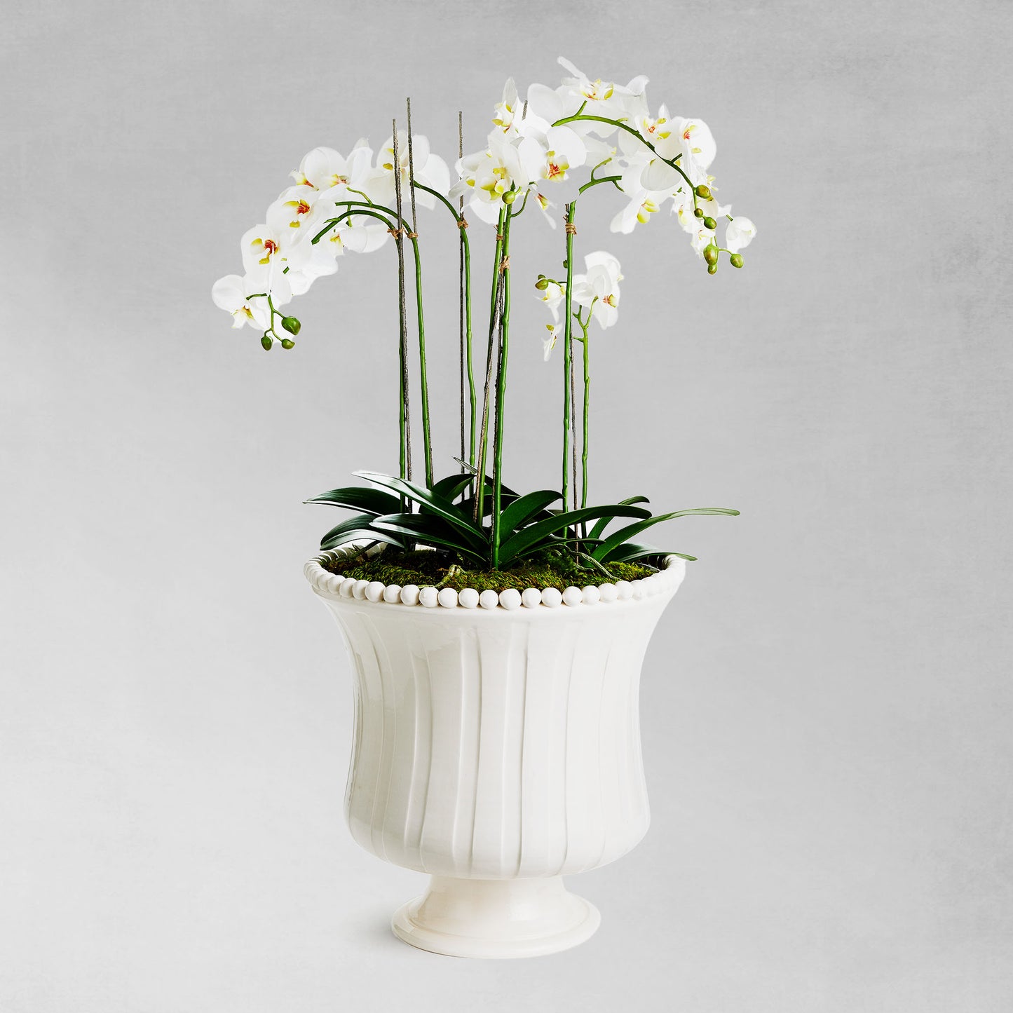 Beaded white flared ceramic vase, large, filled with faux floral orchid drop-in.