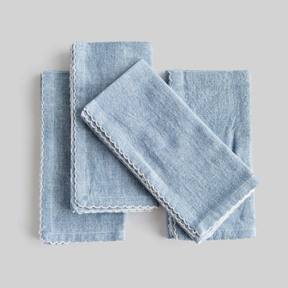 Blue scalloped square cotton dinner napkins set of 4 with gray background.