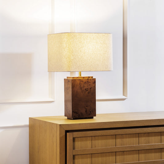 Burl wood table lamp stylized on sideboard table in living room.