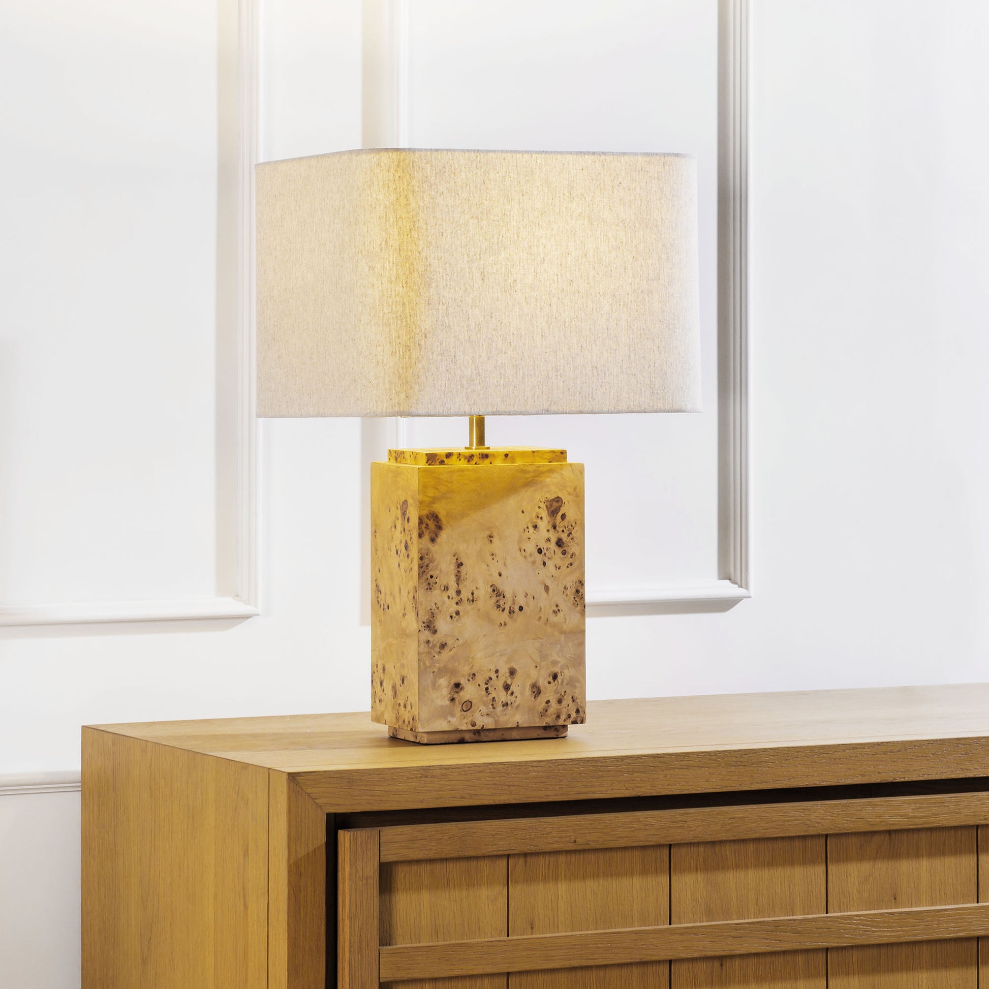 Burl wood table lamp stylized on sideboard table in living room.