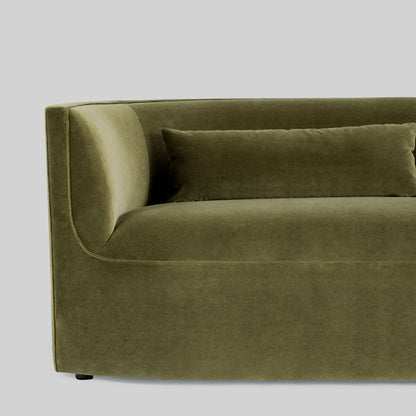 Green fabric sofa on a light gray background.