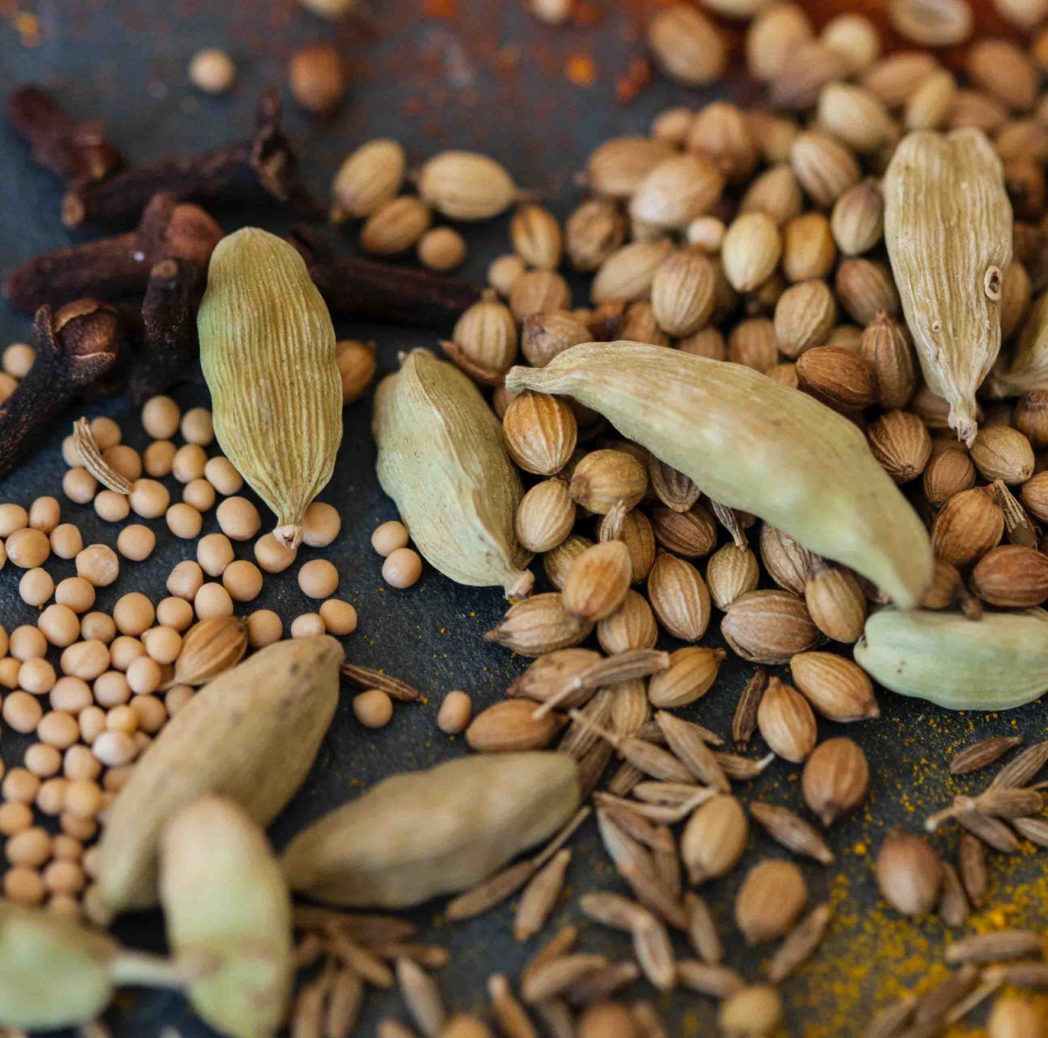 Cardamom shells and seeds on table.